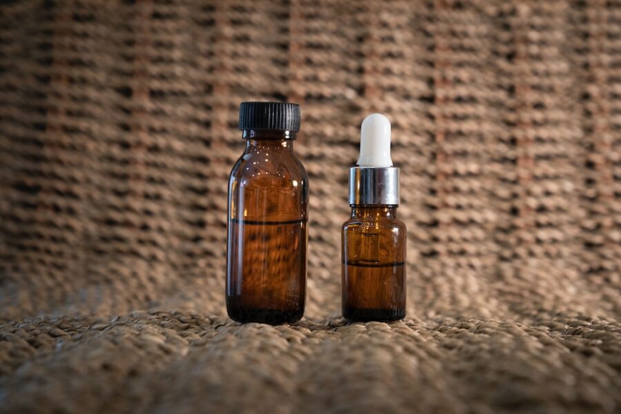 two bottles of detox serum sitting on a cloth